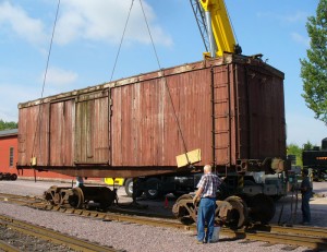 A crane unloads LS&I boxcar #2011
