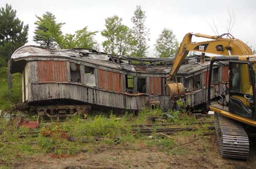 collapsed passenger railcar with excavator