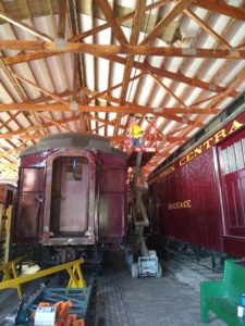 worker on lift next to train cars