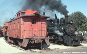 C&NW #12476 wooden caboose (ex-LS&I) next to D&R #9 at depot platform, North Freedom, smoke effect.  Oct. 1970.  Ektachrome 35mm transparency.  Philip A. Weibler photo