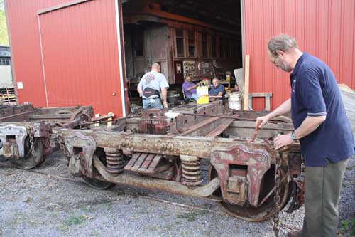 volunteer applying linseed oil to car trucks